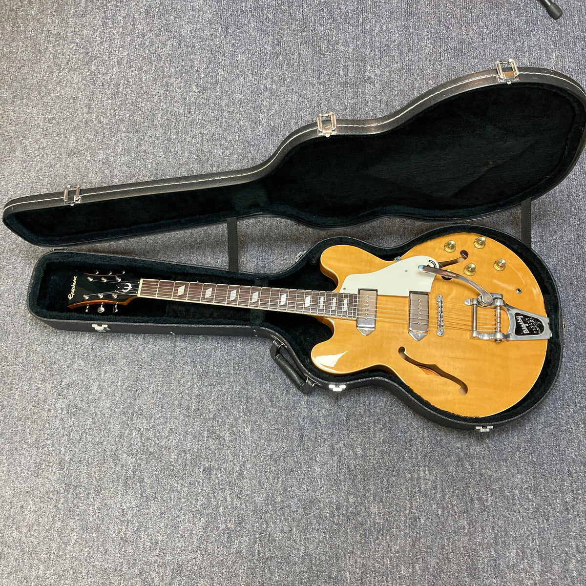 Epiphone Casino Reissue 1995 guitar in case, showcasing its hollow body and neck with parallelogram inlays, ideal for collectors and players.