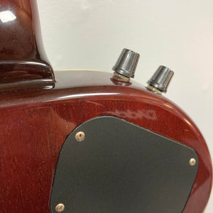 Close-up of the back of an Epiphone Chet Atkins SST Studio Natural electric guitar, showing two control knobs, part of the neck, and a black cover plate—this feedback-resistant acoustic electric uses a piezo pickup.