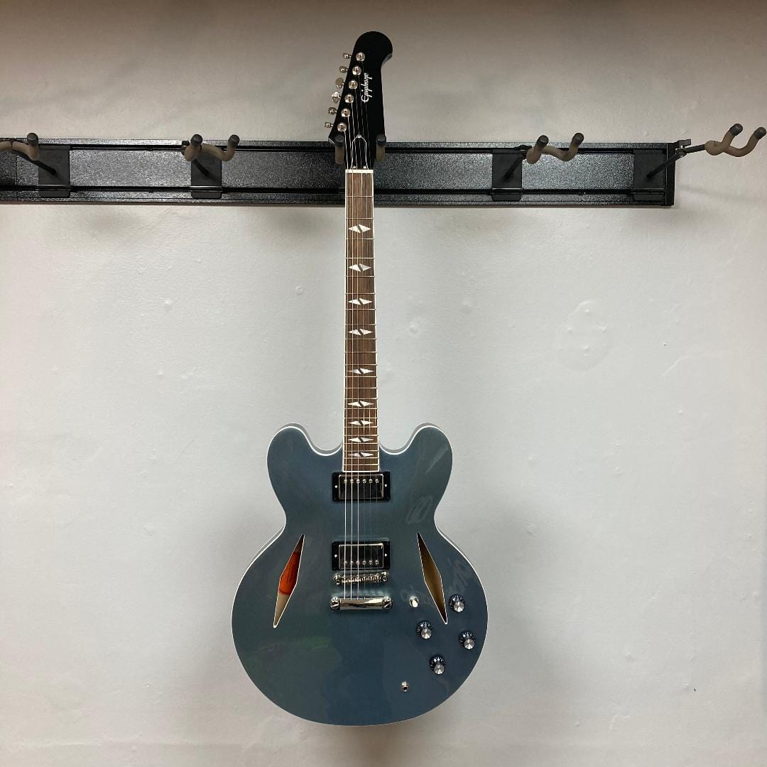 Epiphone Dave Grohl DG-335 guitar on a wall hook, showcasing its intricate design and craftsmanship.