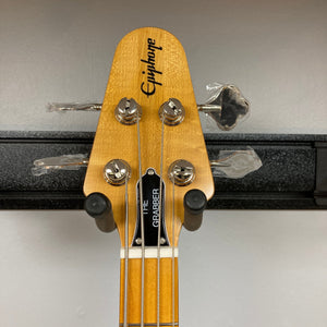 Epiphone Grabber Bass Ebony on stand, showcasing its sleek alder body, maple neck, and hardware, embodying vintage rock style with modern playability.
