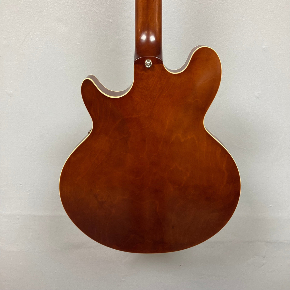 Close-up of the Epiphone Jack Casady Fretless Bass - Aged Royal Tan, showcasing its archtop body, layered maple construction, and intricate hardware details.