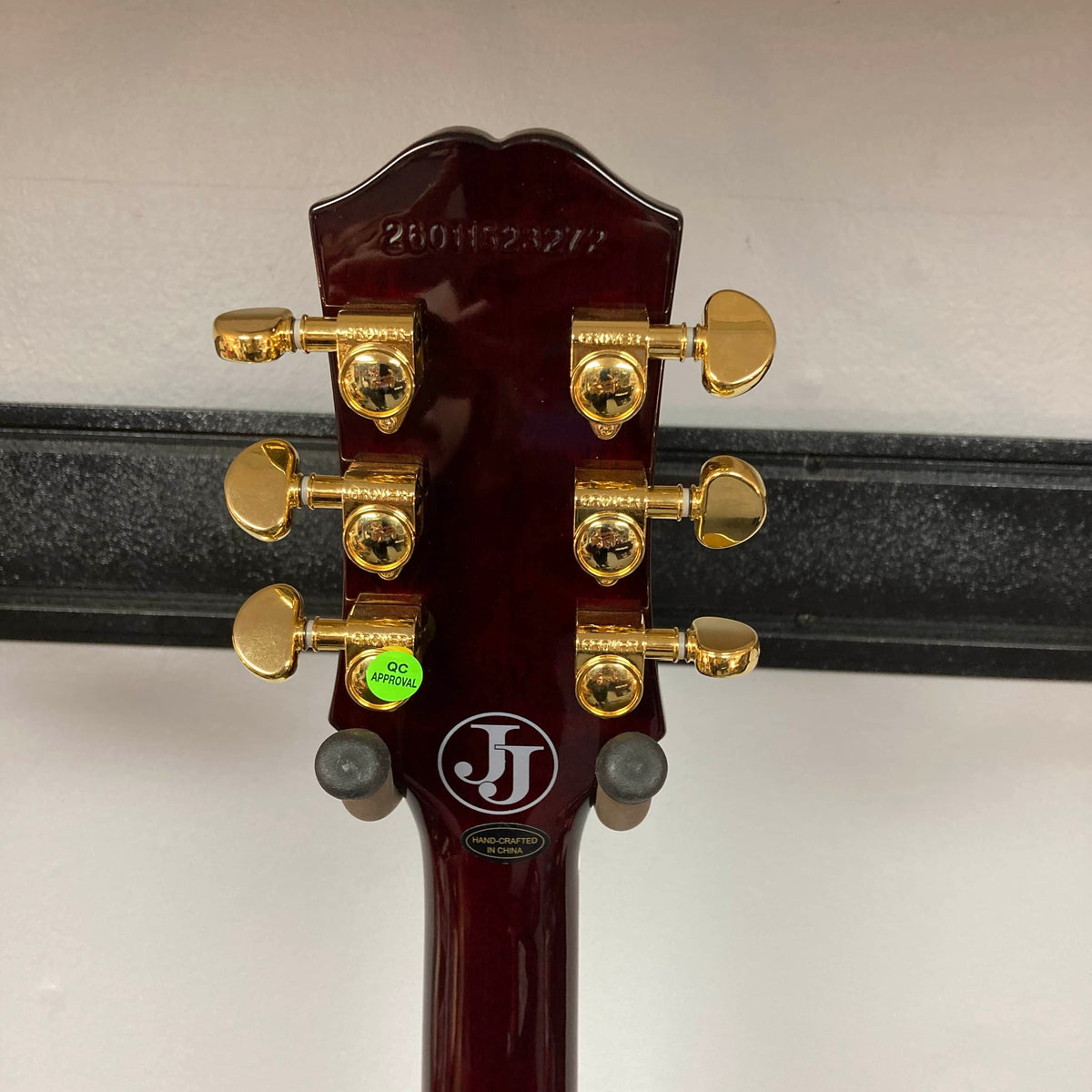 The back of the Epiphone Jerry Cantrell Wino Les Paul Custom in Wine Red features six gold tuners, manufacturer stickers, and a visible serial number on a rich wood grain finish.