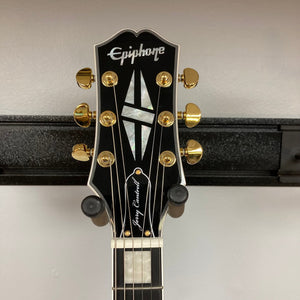 Epiphone Jerry Cantrell Wino Les Paul Custom Wine Red guitar on a stand, showcasing gold hardware and mahogany body.