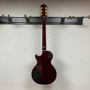 Epiphone Jerry Cantrell Wino Les Paul Custom Wine Red guitar displayed on a wall, showcasing its elegant design and craftsmanship.