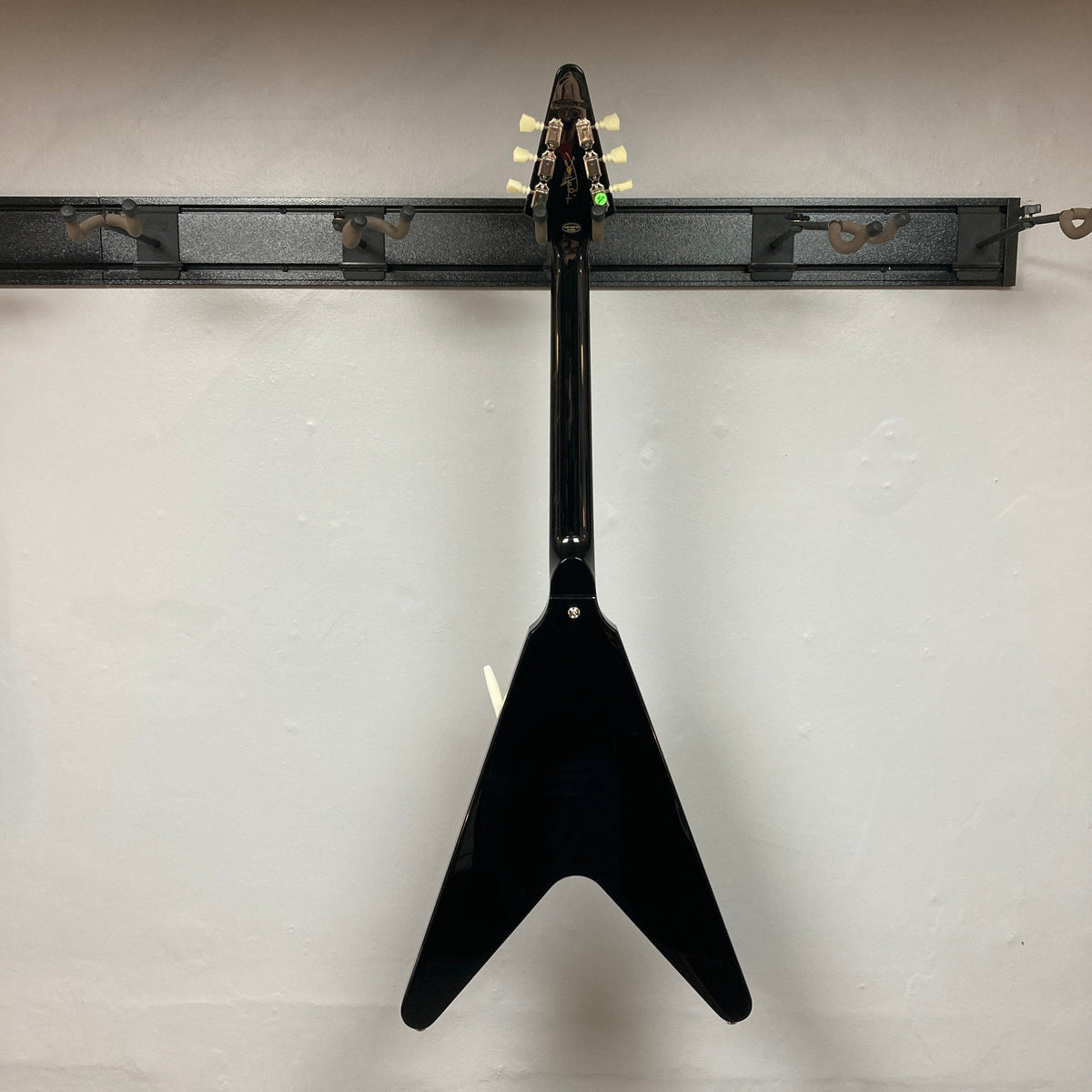 Epiphone Jimi Hendrix Love Drops Flying V guitar, displayed on a wall, showcasing its iconic Flying V design and craftsmanship. Includes hard case.