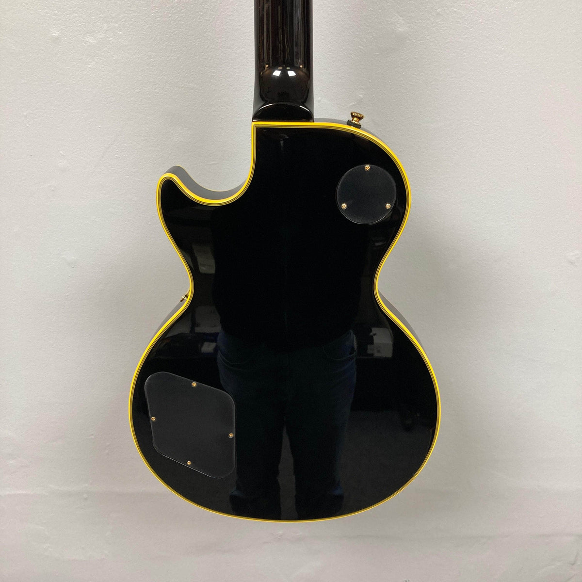 Epiphone Joe Bonamassa 59 Les Paul Custom Bigsby, glossy black with cream binding, rear cavity covers, and strap button, reflecting premium craftsmanship.