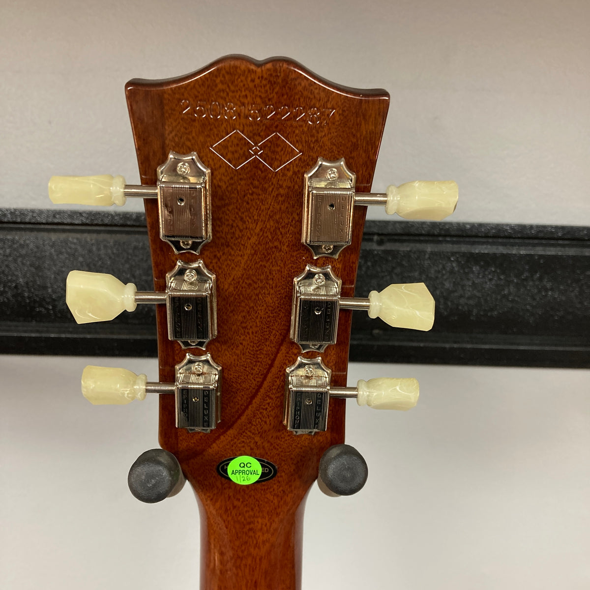Close-up of an Epiphone Les Paul 1957 Goldtop Reissue Blem headstock, featuring six tuning pegs, serial number, decorative inlay, and a green "QC approved" sticker on the back—evoking classic Goldtop style.