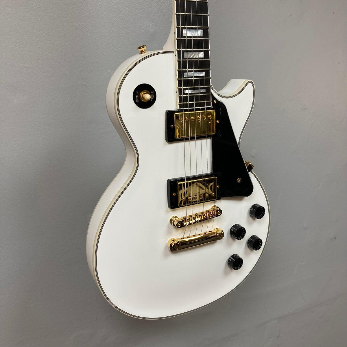 Epiphone Les Paul Custom Inspired by Gibson in Alpine White, featuring gold hardware, ebony fretboard, mother-of-pearl inlays, and comes with a black hardshell case.