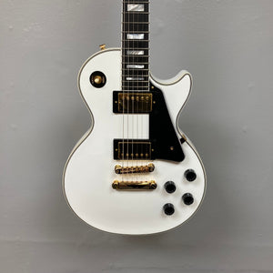 Epiphone Les Paul Custom Inspired by Gibson Alpine White electric guitar with gold hardware, black accents, and hardshell case.
