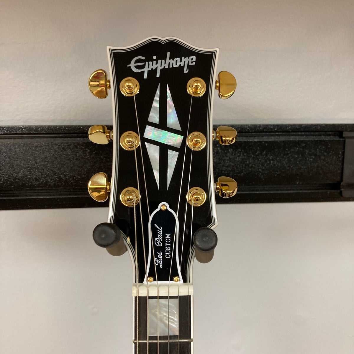 Close-up of the Epiphone Les Paul Custom Inspired by Gibson Ebony w/Case, highlighting its neck, strings, and signature hardware details.