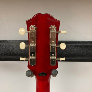 Close-up of the back of an Epiphone Les Paul Special Double Cut Cherry Red w/Gigbag headstock, showing six tuners and a "Hand Crafted in China" label. Classic Epiphone design inspired by Gibson for authentic style and sound.
