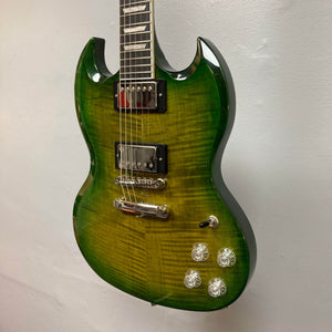An Epiphone SG Modern Figured Iguana Burst electric guitar with a glossy finish, chrome hardware, four control knobs, two ProBucker humbuckers, and a GigBag, shown against a pale wall.