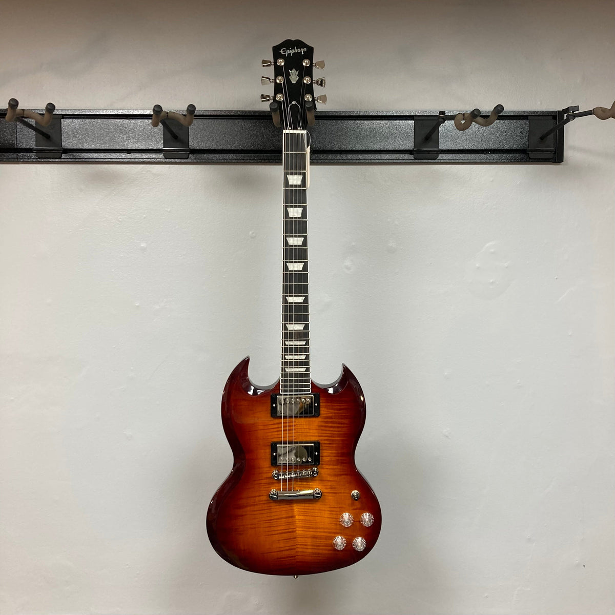 Epiphone SG Modern Figured Mojave Burst guitar with ProBucker pickups, ebony fingerboard, and asymmetrical SlimTaper neck, displayed on a wall. Comes with a premium gig bag.