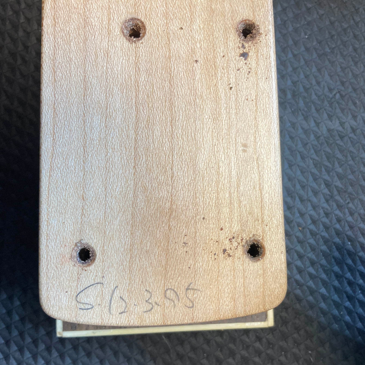 A close-up of the ESP Standard Eclipse Transparent Cherry Red guitar body by Esp, showing four drilled holes and "CL 395" handwritten at the bottom, set against a textured dark background.