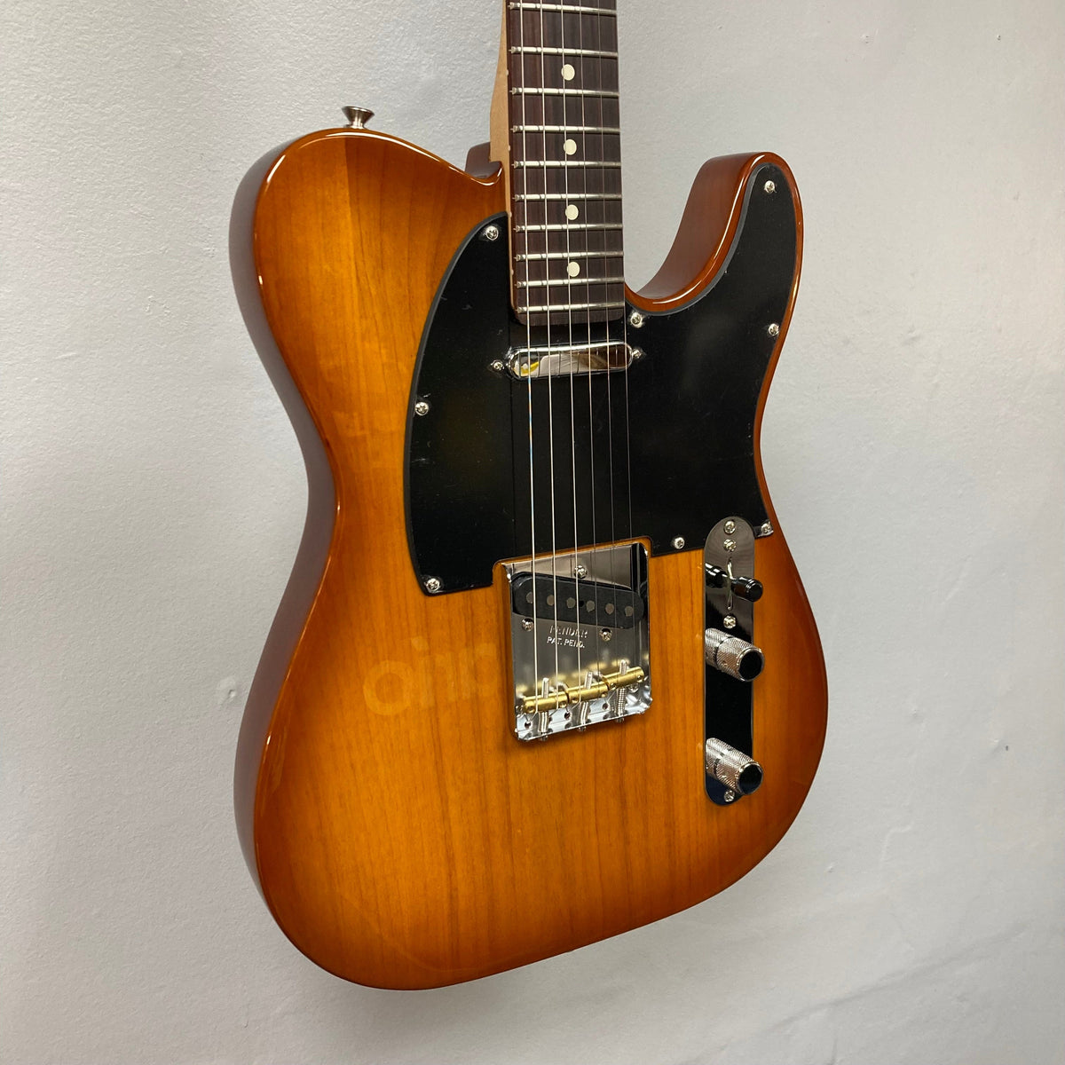 Fender American Performer Telecaster Honeyburst, electric guitar, wall-mounted, showcasing its sleek design and maple neck. Comes with a gig bag.