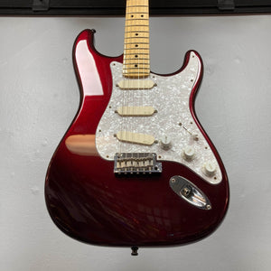 A Fender American Standard Strat upgraded Gilmour EMG DC-20 in Bordeaux Metallic, featuring a white pearl pickguard, three EMG DG20 David Gilmour pickups, and a maple neck, is mounted on a light gray wall.