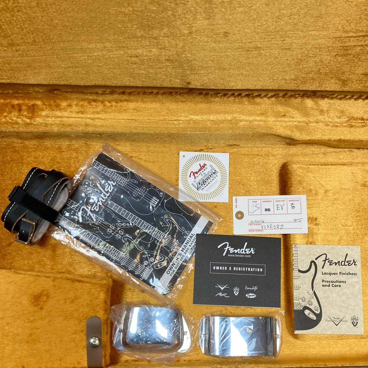 The Fender American Vintage '62 Precision Bass Olympic White 2005 w/Case includes strap, owner's manual, registration card, lacquer finish guide, stickers, and two metal covers—perfect for your vintage reissue.