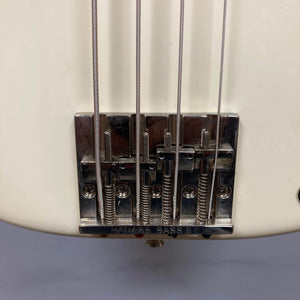 Close-up of the bridge and strings on a Fender American Vintage '62 Precision Bass in Olympic White (2005), with "HADASS BASS" engraved on the metal bridge plate.