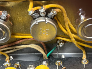 Close-up of vintage electronic parts—20K potentiometer, resistors, and cloth-covered wires—inside a metal enclosure from a 1957 Fender Bassman 5F6 Narrow Panel 40-Watt 4x10" Guitar Combo w/Flight Case.