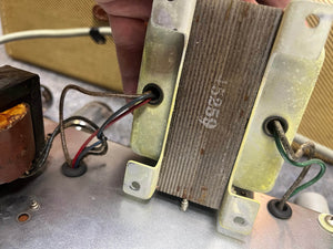 Close-up of a hand holding a transformer labeled “45259,” wired and mounted inside a 1957 Fender Bassman 5F6 Narrow Panel 40-Watt 4x10" Guitar Combo by Fender.