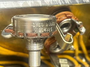 Close-up of a metal rotary potentiometer with serial numbers and brown wiring, mounted on a Fender 1957 Bassman 5F6 Narrow Panel 40-Watt 4x10" Guitar Combo; yellow wires and metal parts are visible in the background.