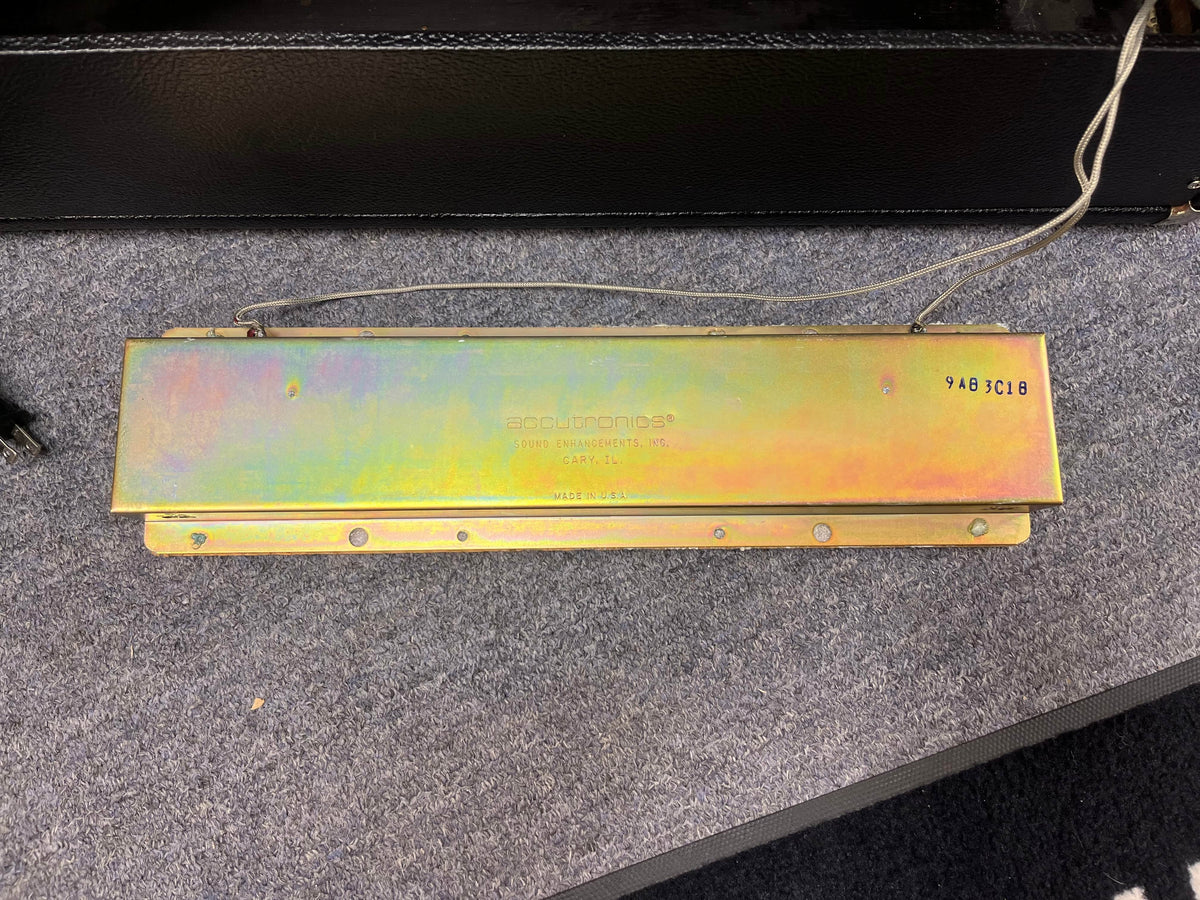 A metallic plate labeled "Accutronics" with wires, marked “9AB3C1B” and “Made in U.S.A.”, shown on gray carpet—a classic component found in the 1966 Fender Black Panel Twin Reverb 2x12" Combo Amp by Fender.