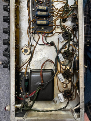 Interior view of a 1966 Fender Black Panel Twin Reverb 2-Channel 85-Watt 2x12" Guitar Combo Amp shows wires, resistors, capacitors on a metal chassis. Control knobs and spring reverb elements are visible. Comes with case. Brand: Fender.