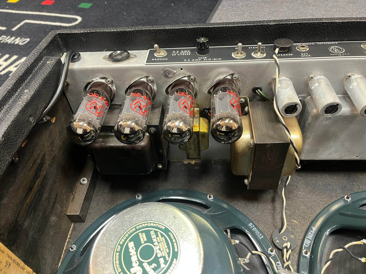 Close-up of the back panel on a 1966 Fender Twin Reverb 2-Channel 85-Watt 2x12" Guitar Combo Amp by Fender, showing four vacuum tubes, detailed wiring, transformers, and parts of two loudspeakers.