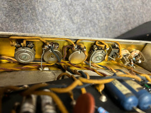 Close-up view of vintage electronic components, like potentiometers and wires, inside the metal chassis of a 1966 Fender Twin Reverb 2-Channel 85-Watt 2x12" Guitar Combo Amp w/Flight Case by Fender.