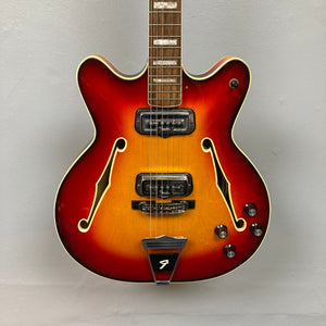Fender Coronado II 1973 Sunburst: Semi-hollow electric guitar with dual humbuckers, visible strings, and minor finish wear. Comes with a case.
