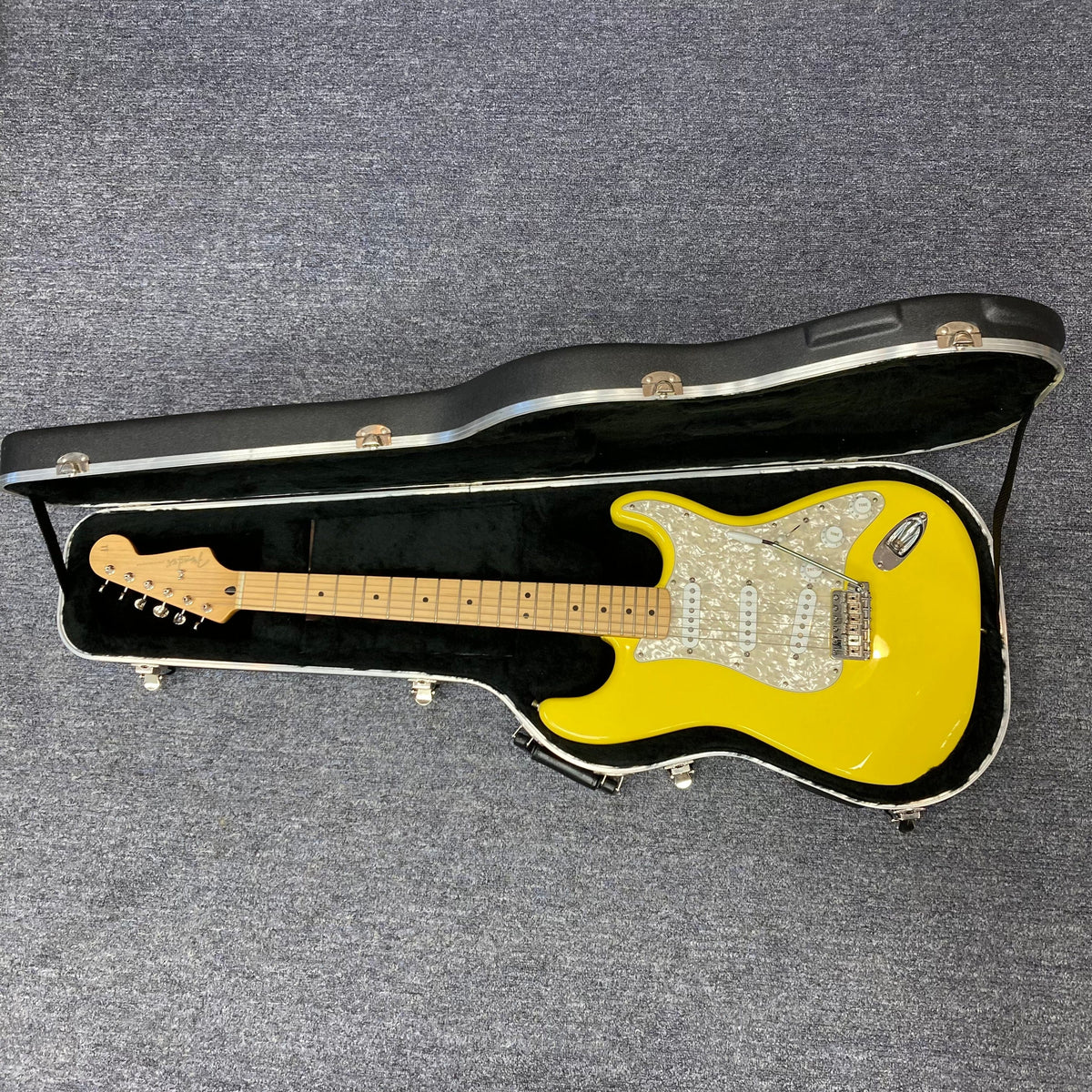 Fender Deluxe Powerhouse Stratocaster MIM Rare Graffitti Yellow electric guitar in a hard case.