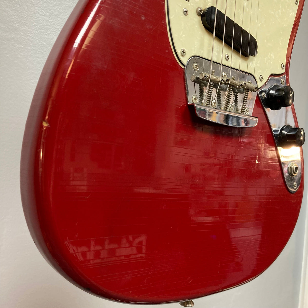 Close-up of a Fender Duo-Sonic II Dakota Red 1966 Vintage electric guitar, showing dual pickups and minor finish blemishes.