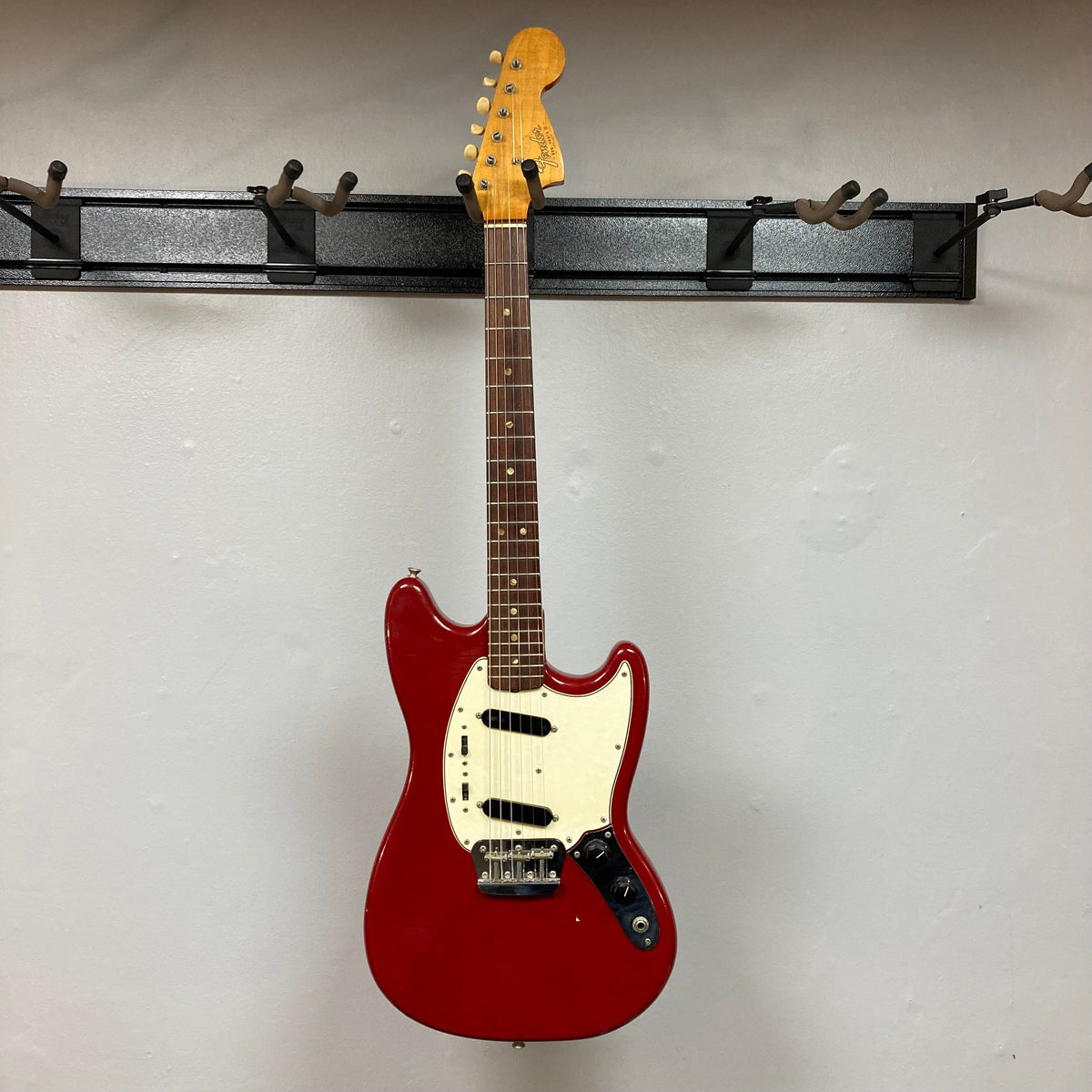 Fender Duo-Sonic II Dakota Red 1966 Vintage electric guitar with minor blemishes and heavy finish checking, displayed on a hook.