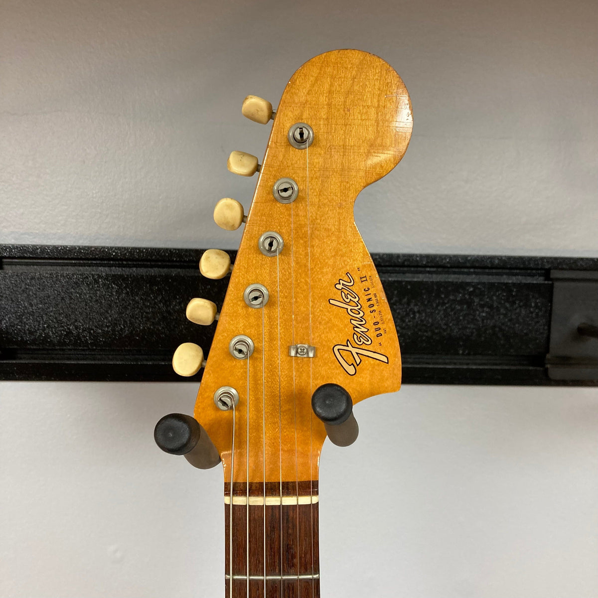 Fender Duo-Sonic II Dakota Red 1966 Vintage guitar on a stand, showing minor blemishes and finish checking, with a case included.