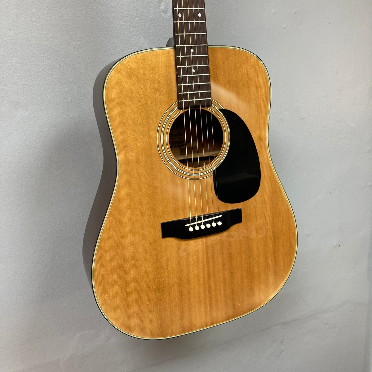 Fender F-35 1972-1981 Natural MIJ guitar, close-up of strings and body on display, showcasing its vintage craftsmanship and unique wood blend.