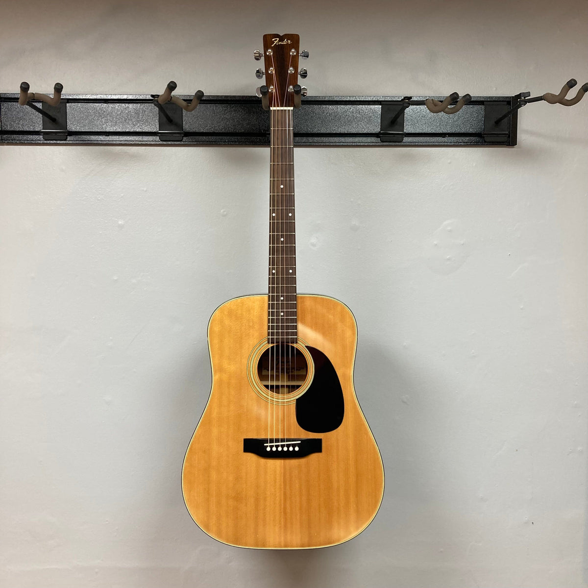 Fender F-35 1972 - 1981 Natural MIJ guitar on a hook, showcasing its vintage craftsmanship and unique Spruce and Obankole blend.