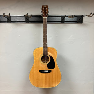 Fender F-35 1972 - 1981 Natural MIJ guitar on a hook, showcasing its vintage craftsmanship and unique Spruce and Obankole blend.