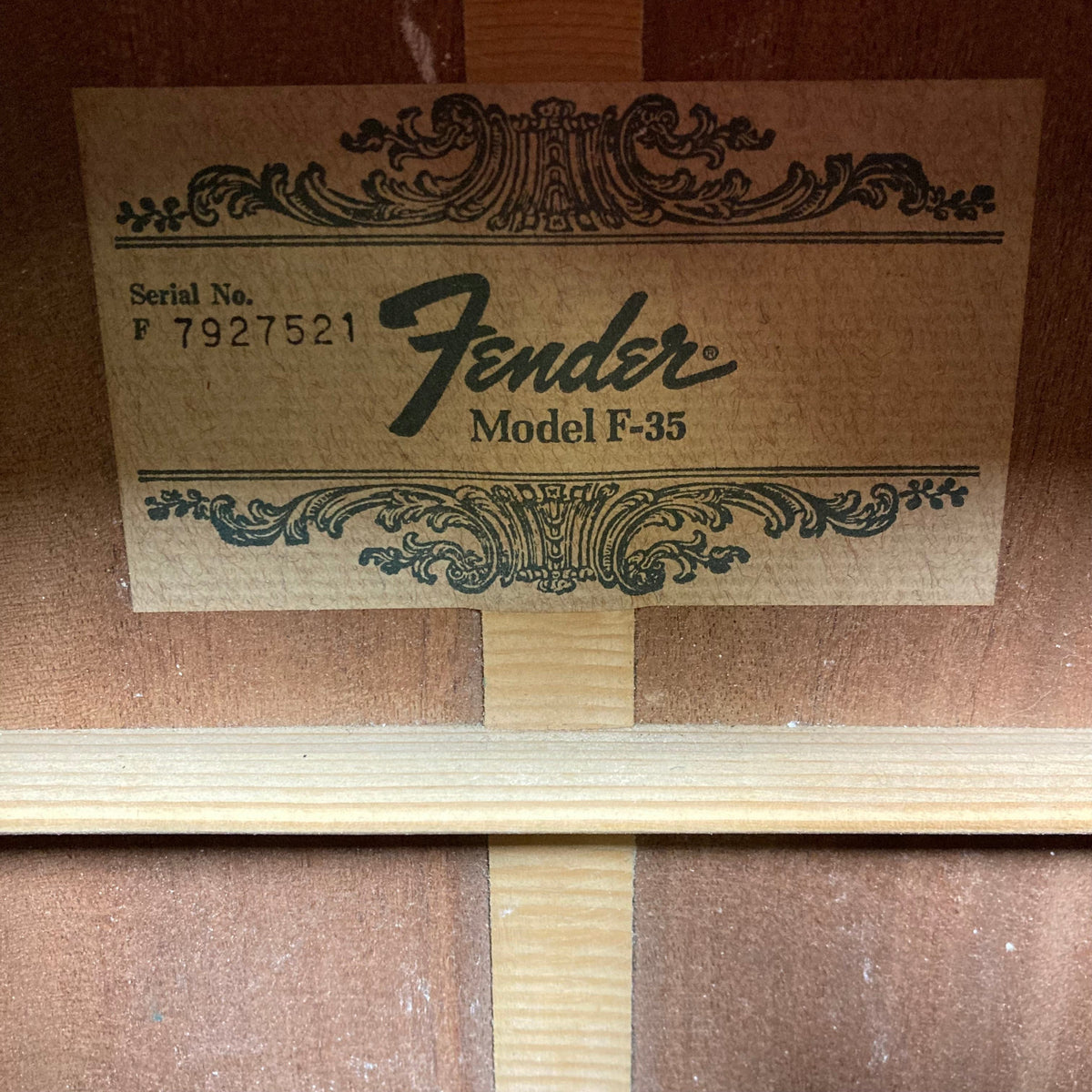 Fender F-35 1972 - 1981 - Natural MIJ label on a wood surface, highlighting its vintage craftsmanship and unique materials.