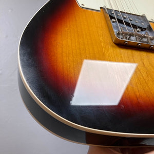 Close-up of a Fender Heritage '60s Telecaster Custom Made in Japan Sunburst w/Gigbag, showing light scratches and a white reflection near the edge—a striking vintage-style electric guitar by Fender.