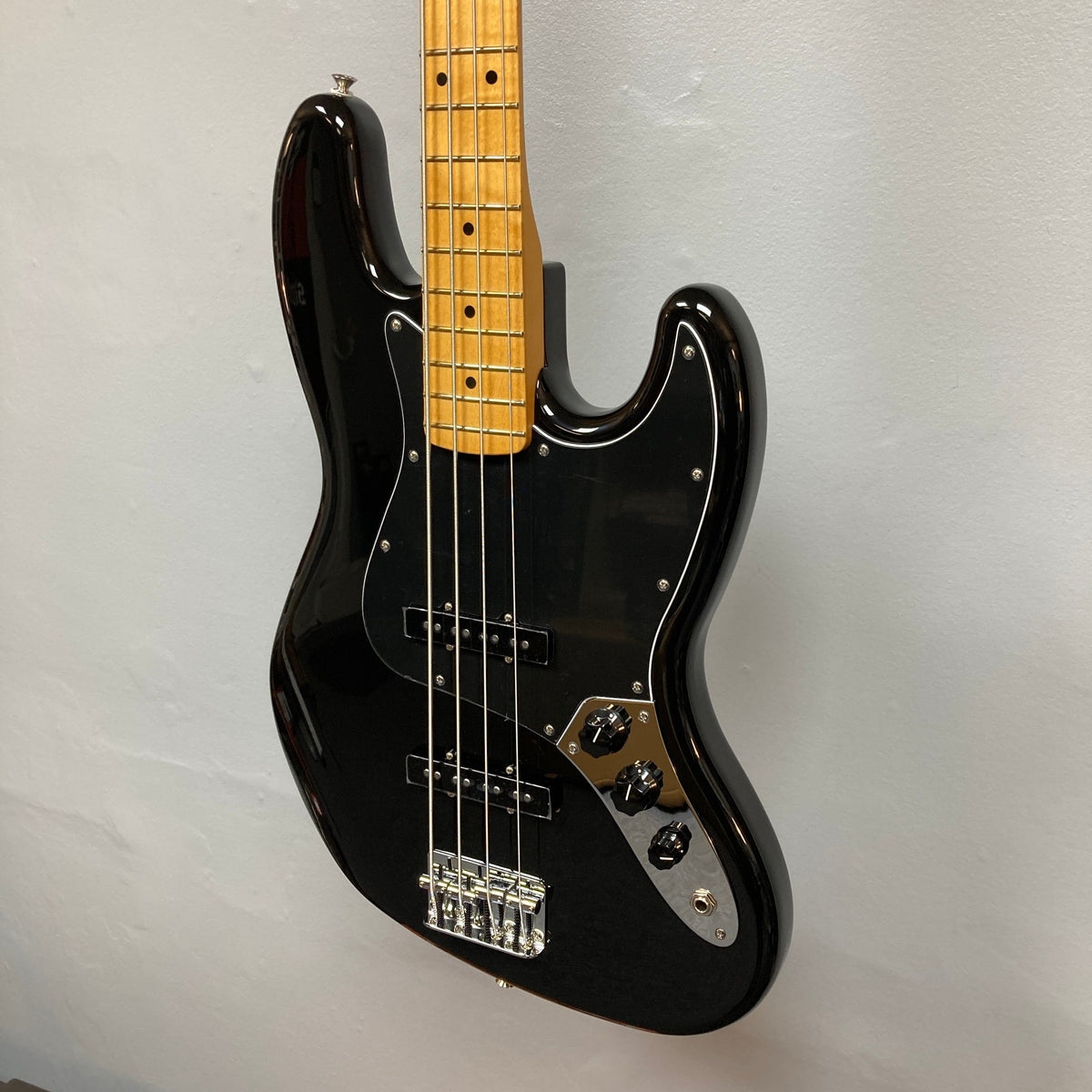 Fender Player II Jazz Bass Black Refurb on display, highlighting its contoured alder body, modern neck profile, and signature pickups for versatile playability.