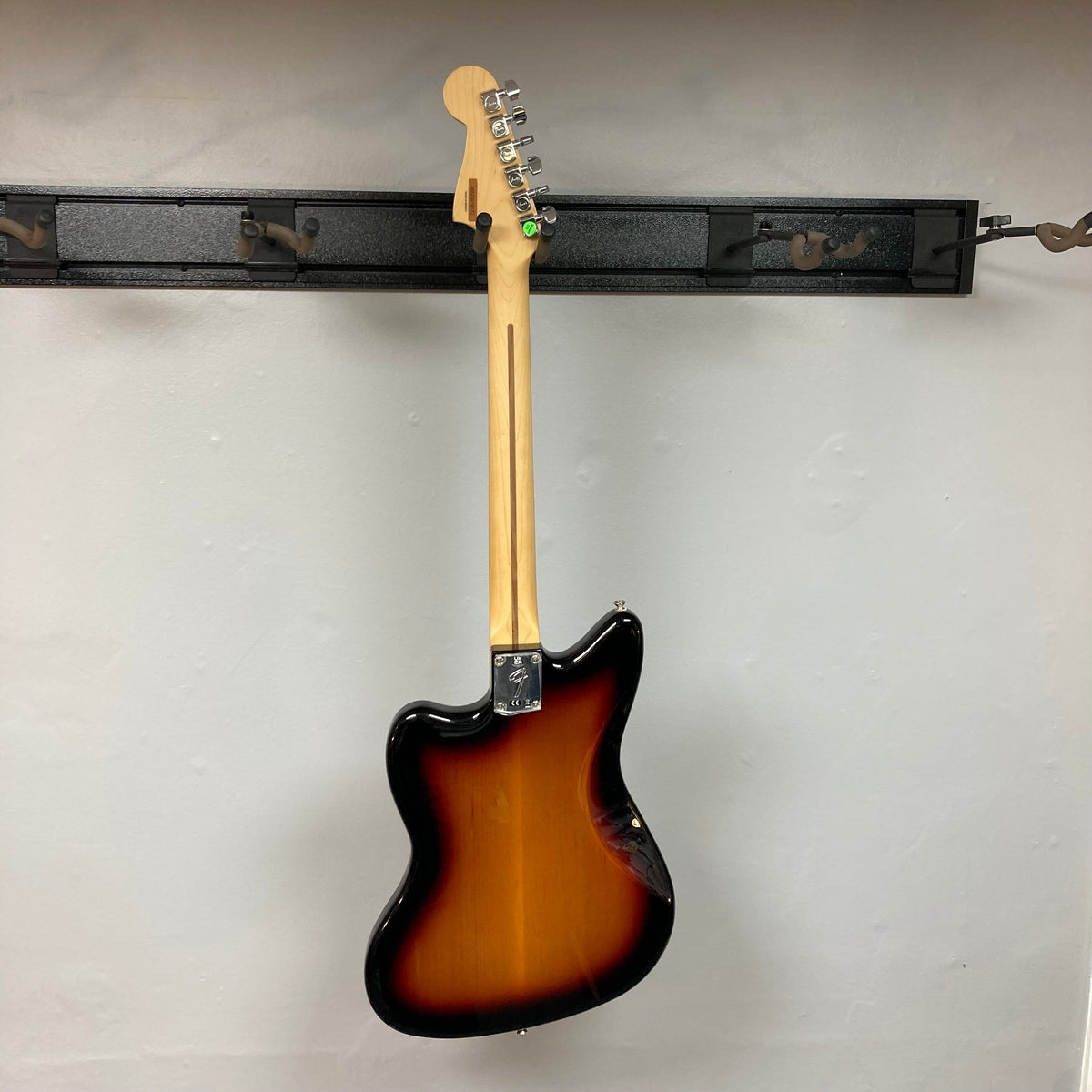 Fender Player Jazzmaster 3-Tone Sunburst Refurb w/Gigbag, mounted on a wall, showcasing its classic design and solid construction.