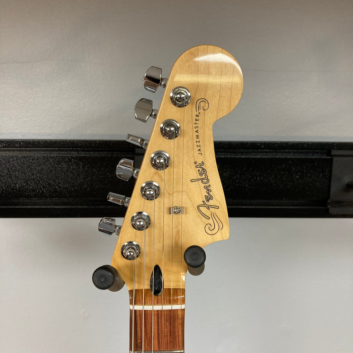 Fender Player Jazzmaster 3-Tone Sunburst Refurb with visible knobs and headstock, highlighting the guitar's detailed craftsmanship and setup quality.