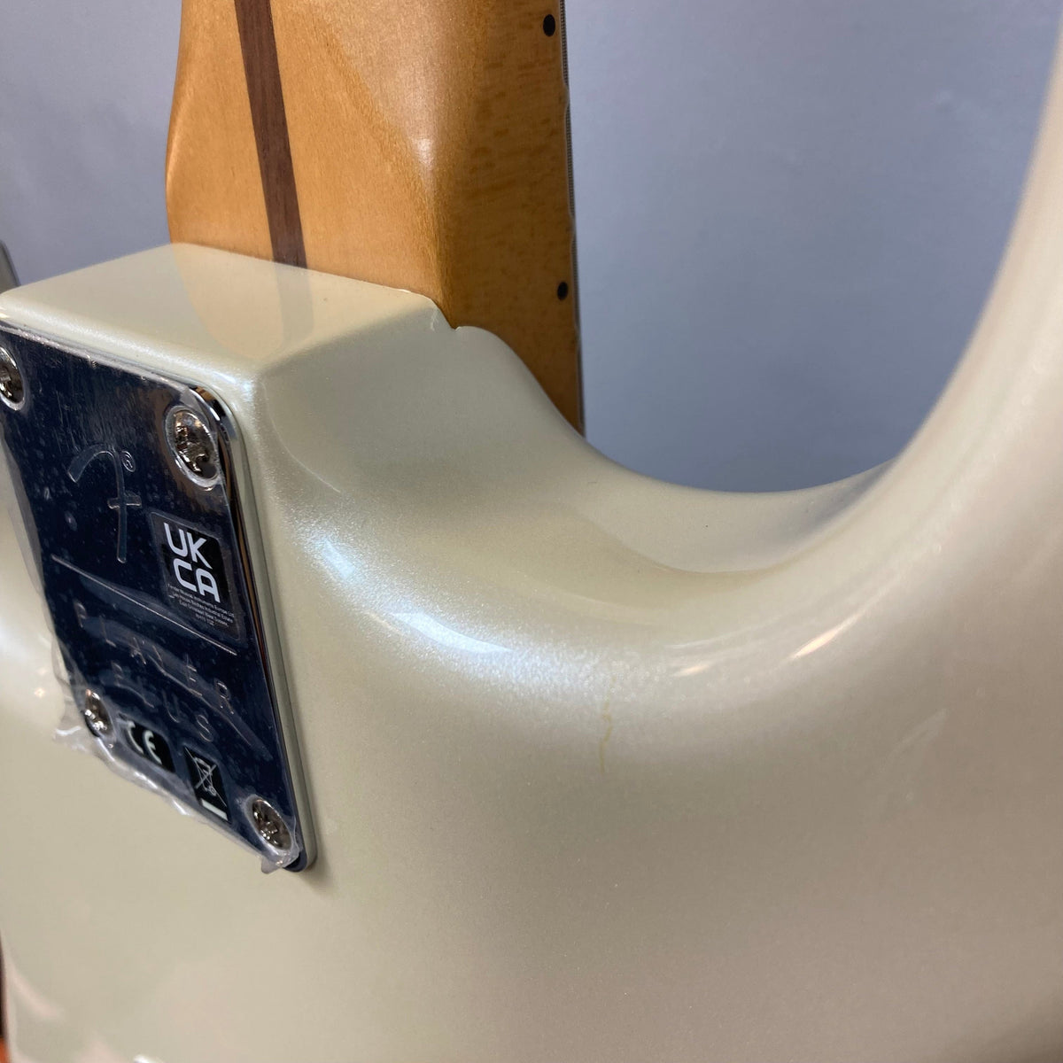 Close-up of Fender Player Plus Stratocaster Olympic Pearl guitar neck and pickups, highlighting the satin-smooth Modern C neck and Player Plus Noiseless™ pickups.