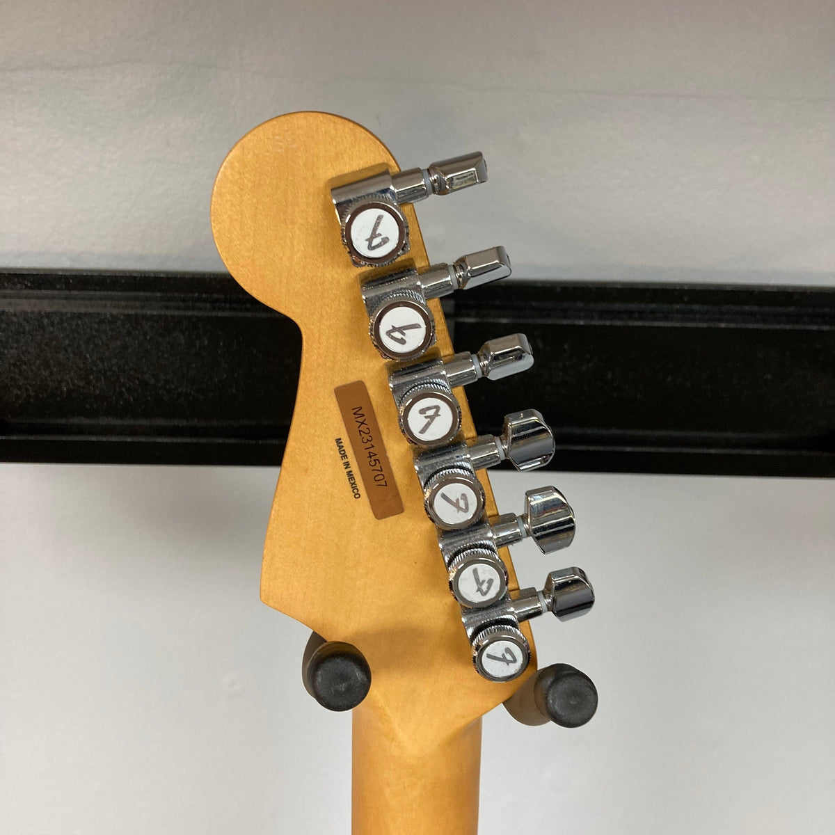 Close-up of a Fender Player Plus Stratocaster Olympic Pearl guitar, highlighting its sleek design and components.