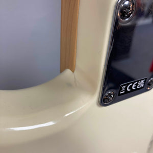 Close-up of the back of a Fender Standard Stratocaster Olympic White Refurb, highlighting the neck joint, cream-colored body, and metal plate with screws and certification markings.