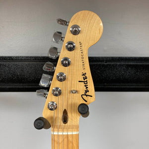 Close-up of a Fender Standard Stratocaster Olympic White Refurb headstock, featuring the Fender logo, tuning pegs, and string guides against a neutral background.