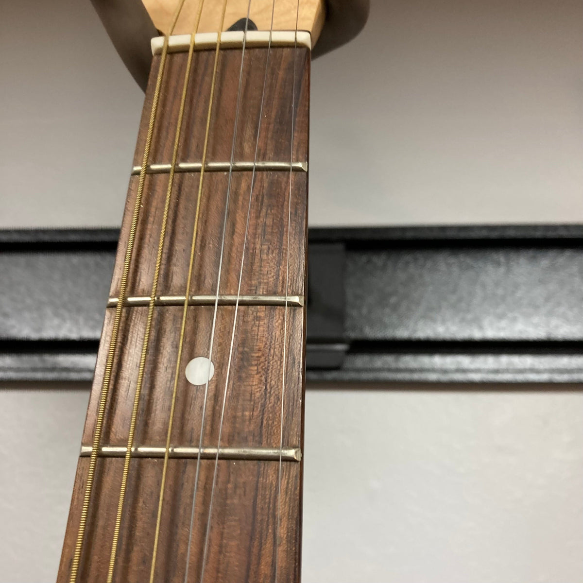 Close-up of the Fender Stratacoustic Pink Paisley guitar neck, highlighting its detailed craftsmanship and built-in electronics for versatile sound.