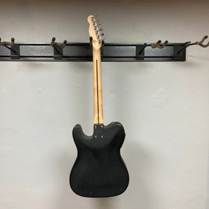 Fender Stratacoustic Pink Paisley guitar with a wooden neck, silver buttons, and built-in electronics, displayed on a wall.