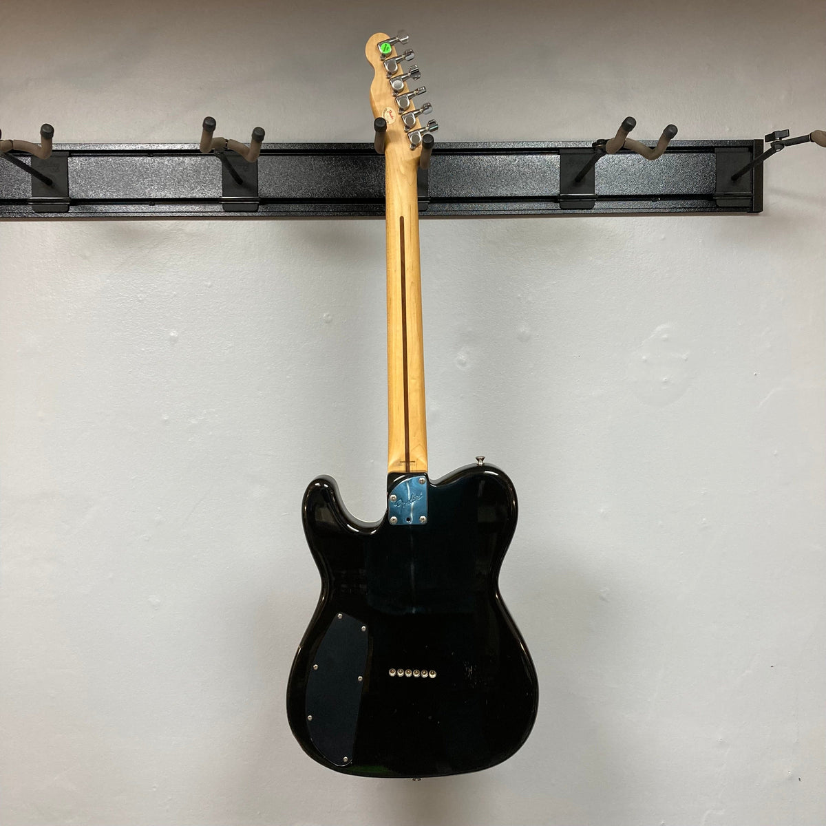 Fender Telecaster TLAC MIJ Acoustic/Electric Hybrid 1993-1997, black electric guitar with a wood neck, silver and blue accents, displayed on a wall.