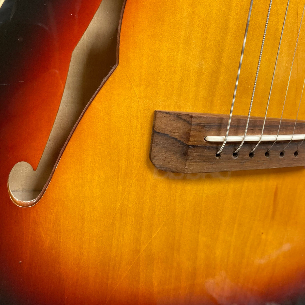 Close-up of a Fender Telecaster TLAC MIJ Acoustic/Electric Hybrid guitar, showcasing its strings and solid body construction.